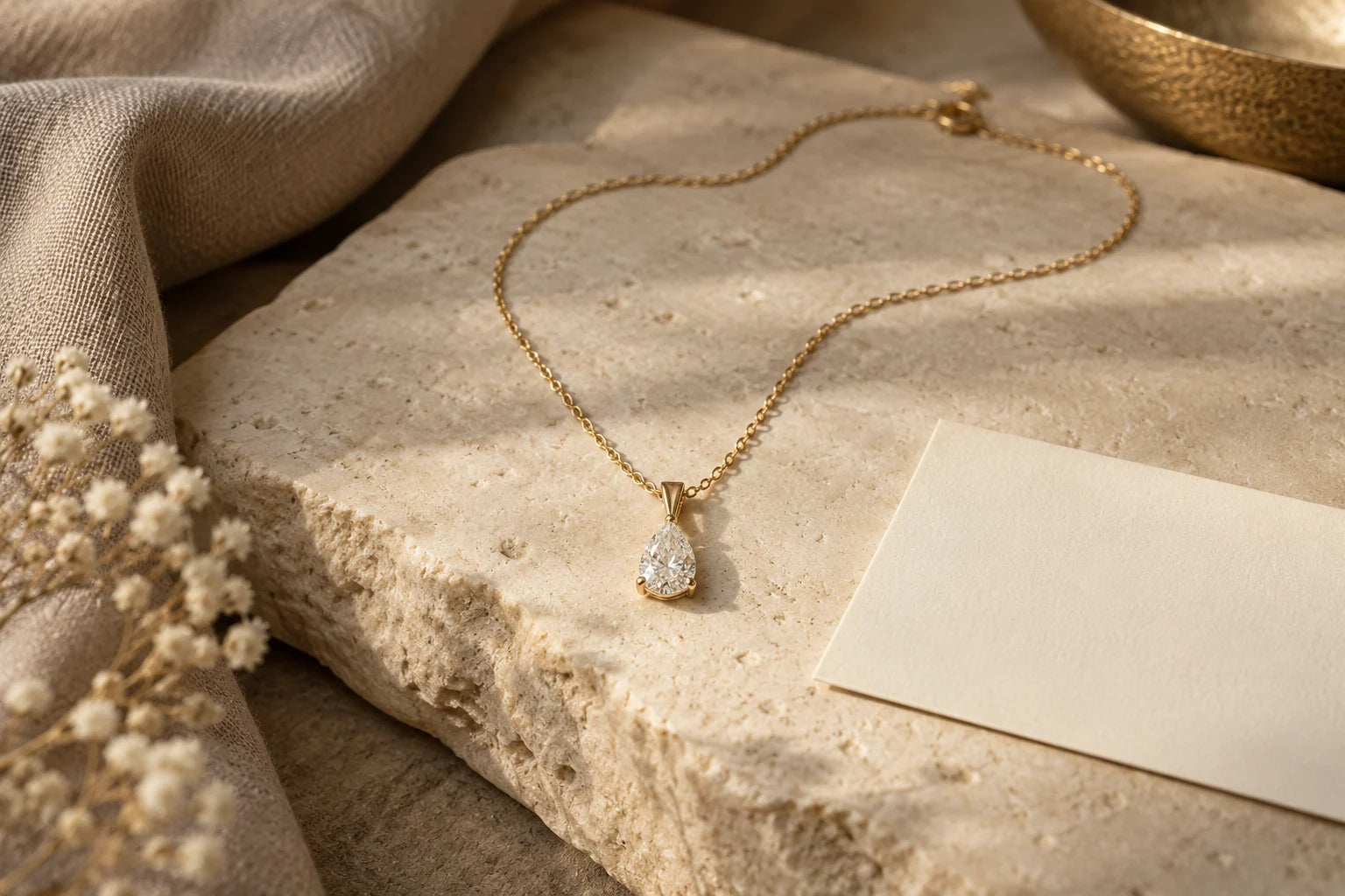 Editorial illustration of a pear diamond necklace on warm ivory stone